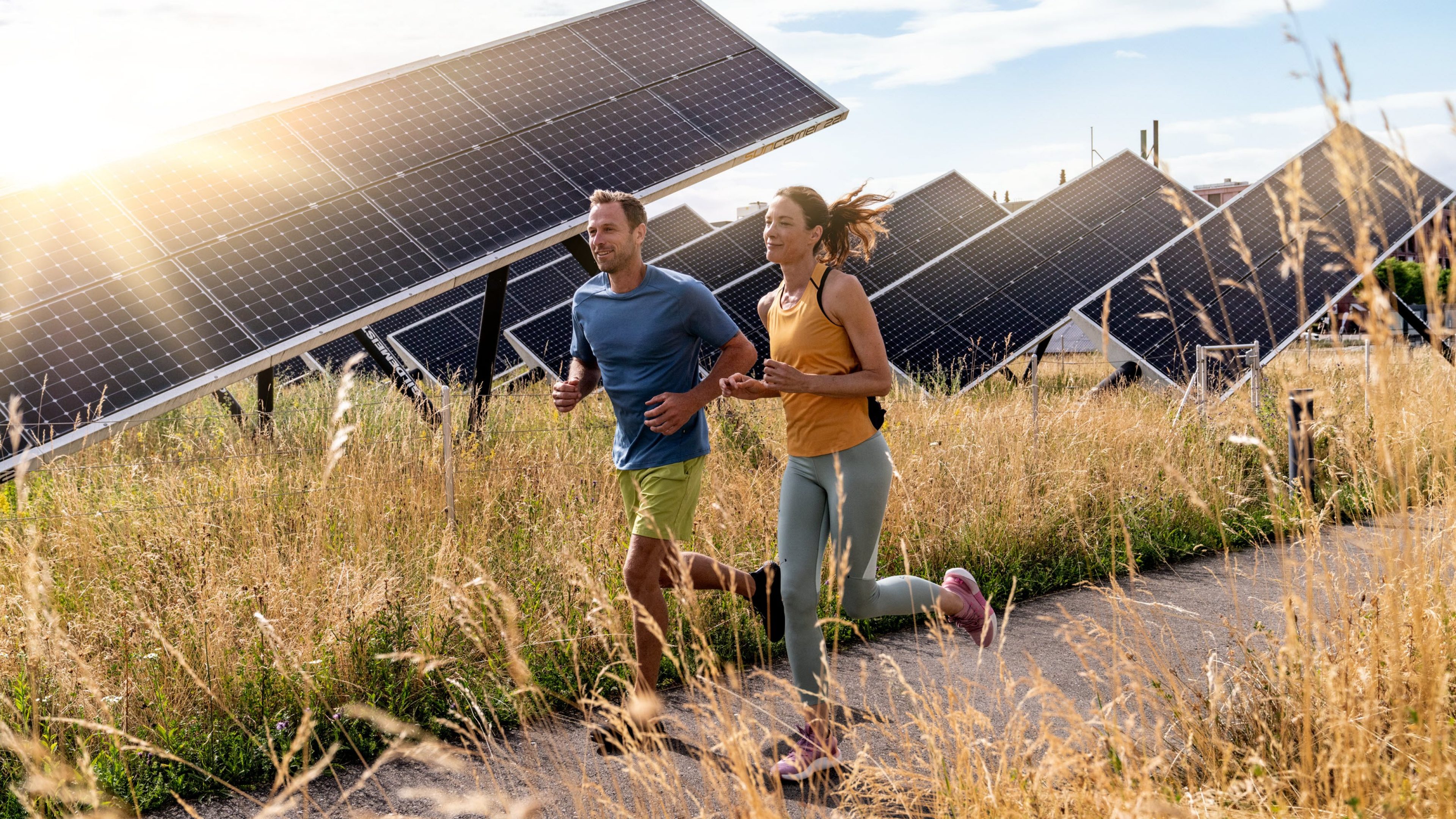 Un couple court au milieu de panneaux solaires.